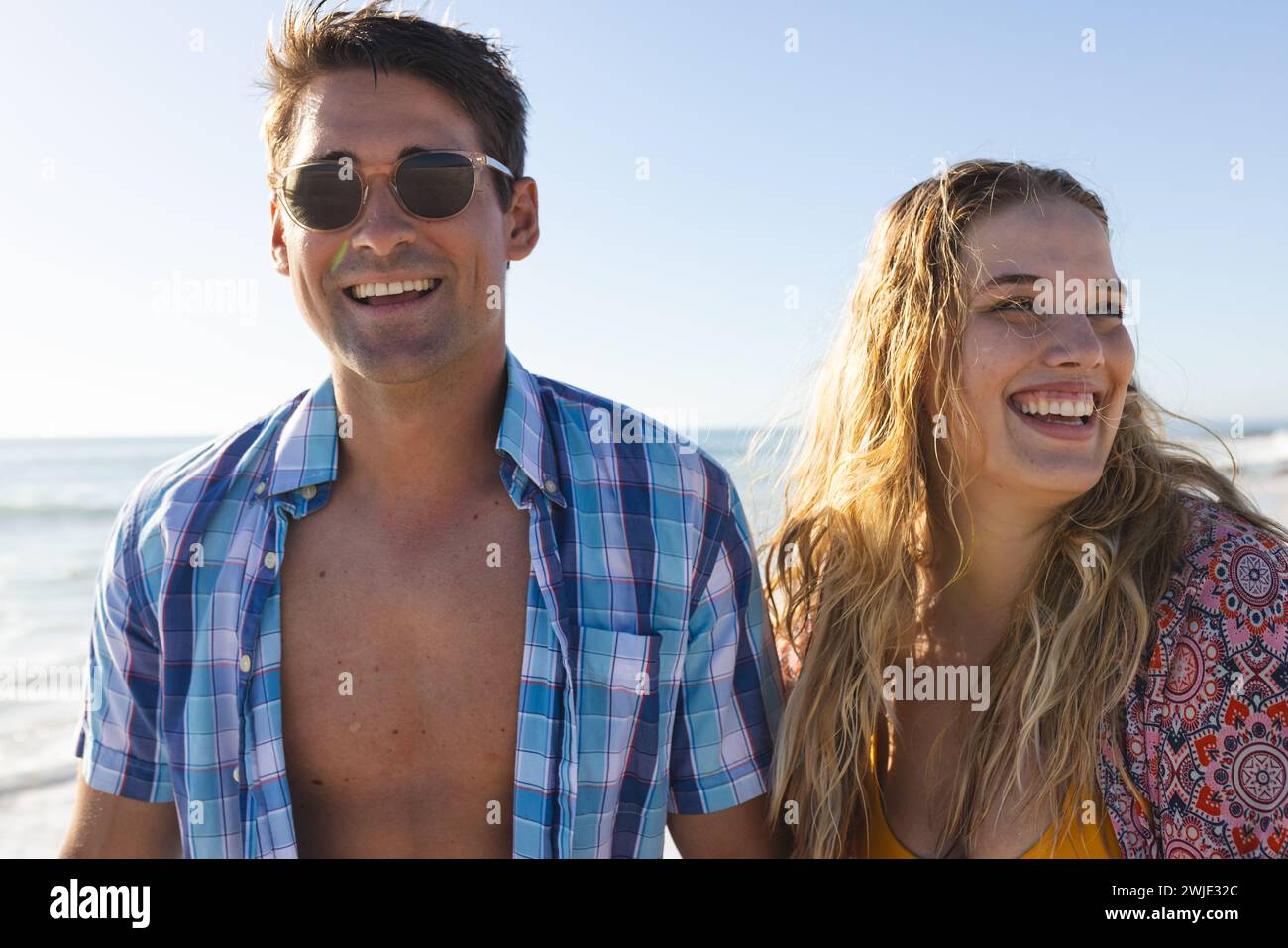 Un couple caucasien profite d'une journée ensoleillée à la plage Banque D'Images