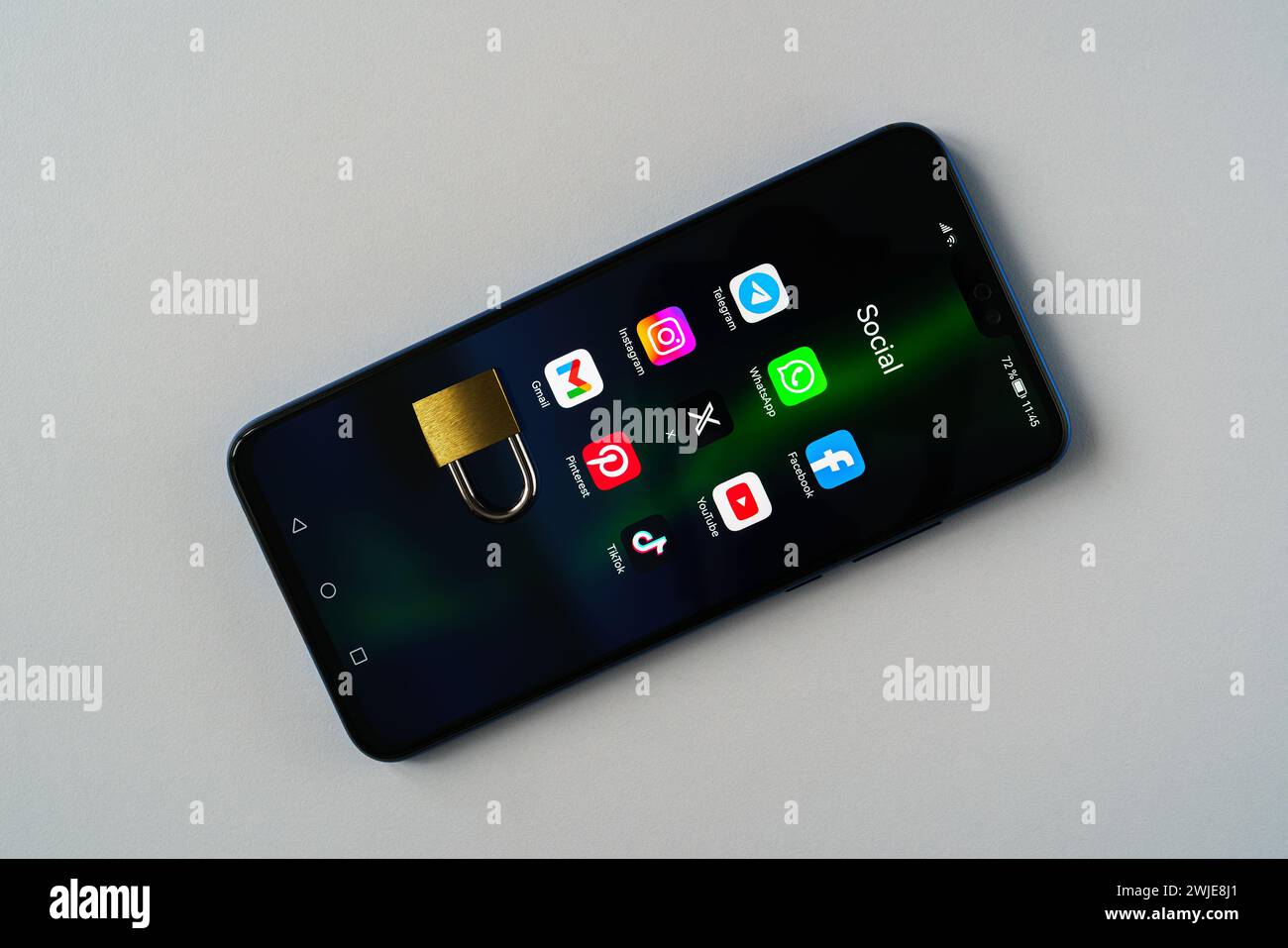 Ouzbékistan, Tachkent - 27 janvier 2024 : un cadenas couché sur l'écran d'un téléphone portable avec des icônes de médias sociaux dessus. Le concept de limitation du temps sur la socia Banque D'Images