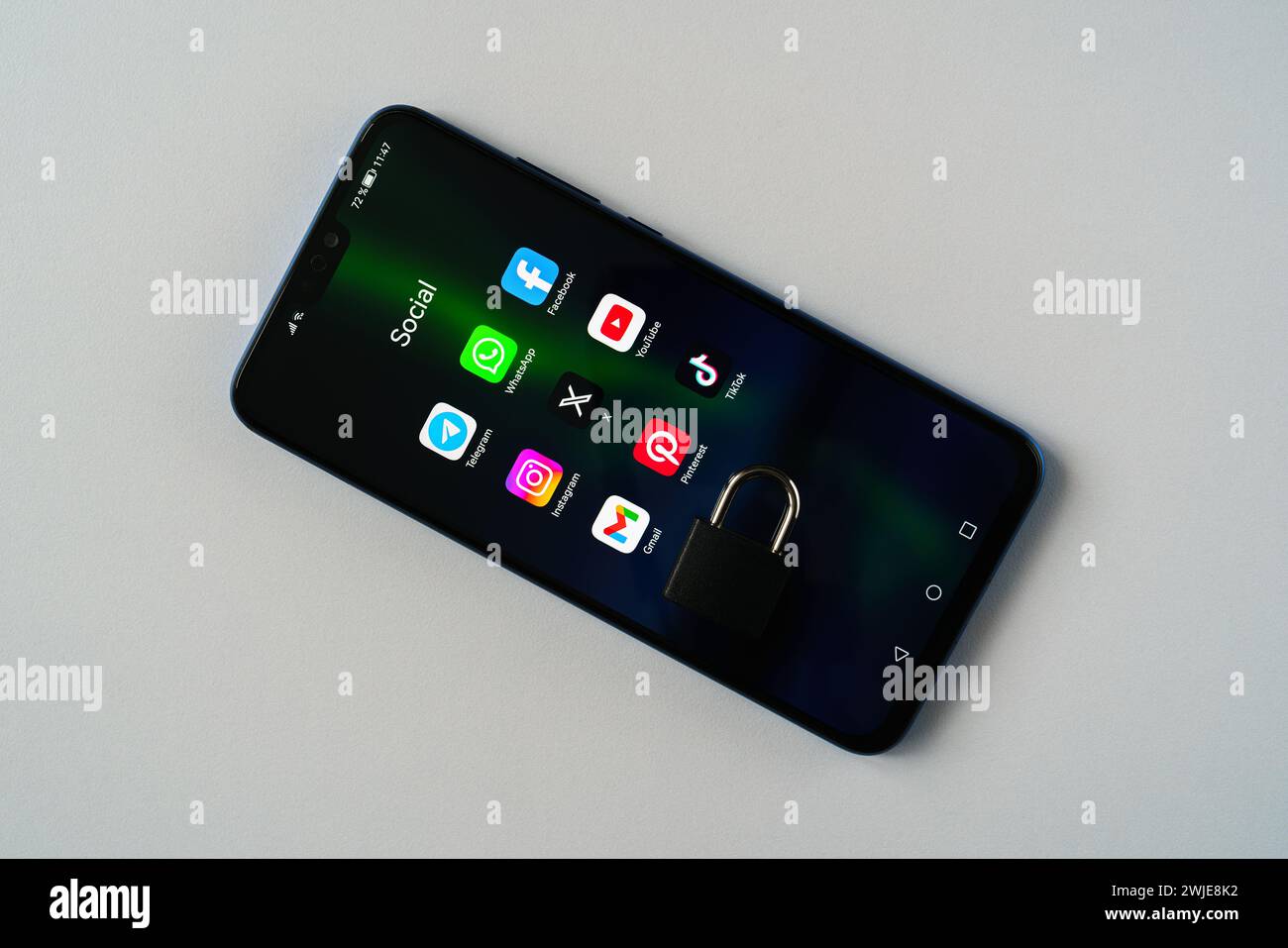 Ouzbékistan, Tachkent - 27 janvier 2024 : un cadenas couché sur l'écran d'un téléphone portable avec des icônes de médias sociaux dessus. Le concept de limitation du temps sur la socia Banque D'Images