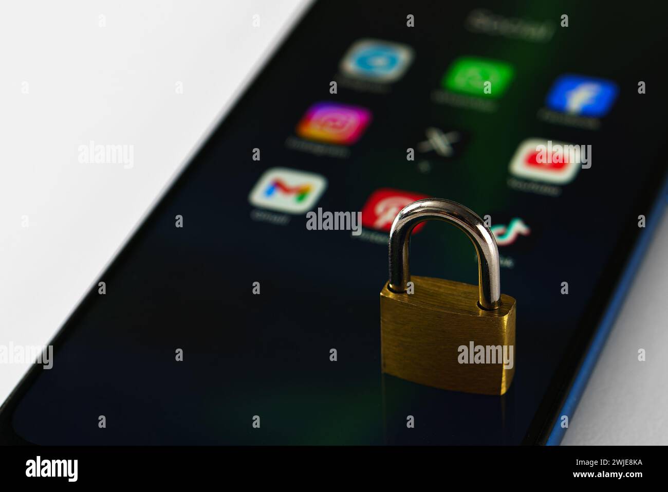Ouzbékistan, Tachkent - 27 janvier 2024 : un cadenas couché sur l'écran d'un téléphone portable avec des icônes de médias sociaux dessus. Le concept de limitation du temps sur la socia Banque D'Images