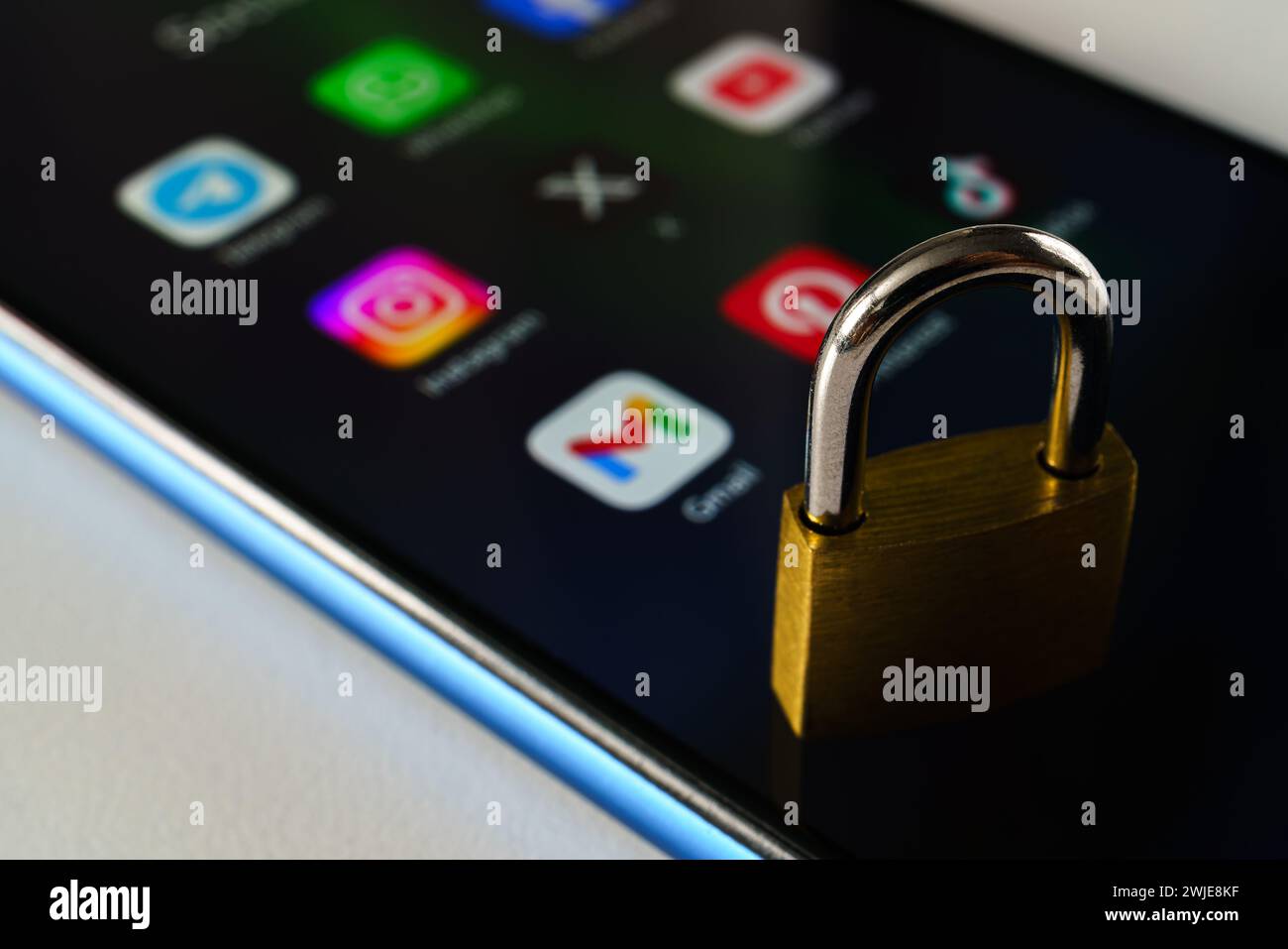 Ouzbékistan, Tachkent - 27 janvier 2024 : un cadenas couché sur l'écran d'un téléphone portable avec des icônes de médias sociaux dessus. Le concept de limitation du temps sur la socia Banque D'Images