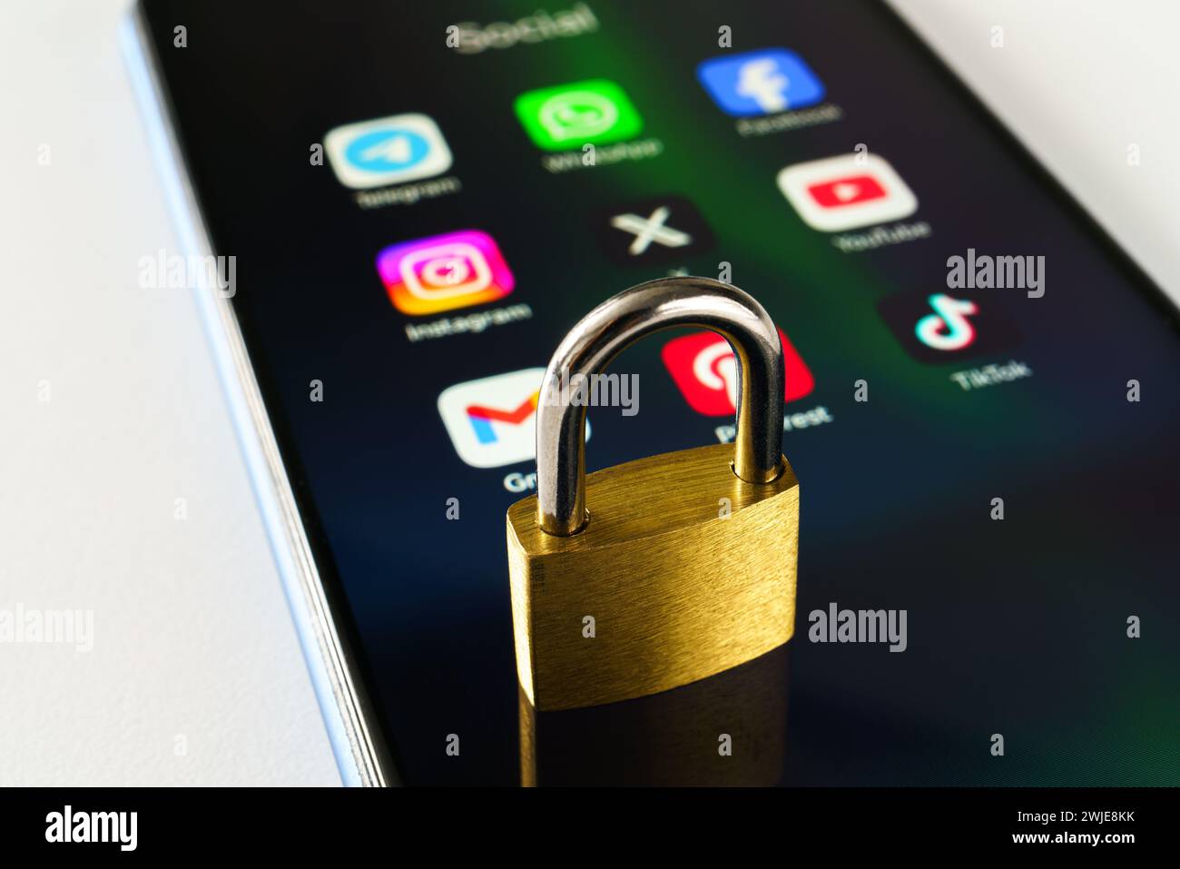 Ouzbékistan, Tachkent - 27 janvier 2024 : un cadenas couché sur l'écran d'un téléphone portable avec des icônes de médias sociaux dessus. Le concept de limitation du temps sur la socia Banque D'Images