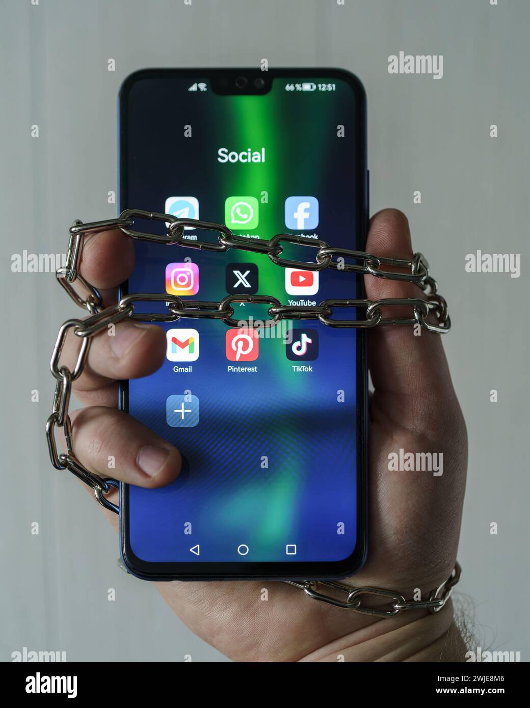 Ouzbékistan, Tachkent - 27 janvier 2024 : chaîne à portée de main avec téléphone mobile avec icônes de réseau social. Concept de limitation du temps sur les réseaux sociaux, addic Banque D'Images