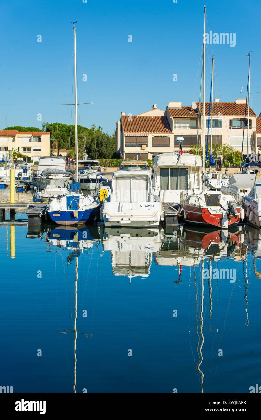 Saint-Cyprien (sud de la France) : bâtiments et bateaux dans le lagon Banque D'Images