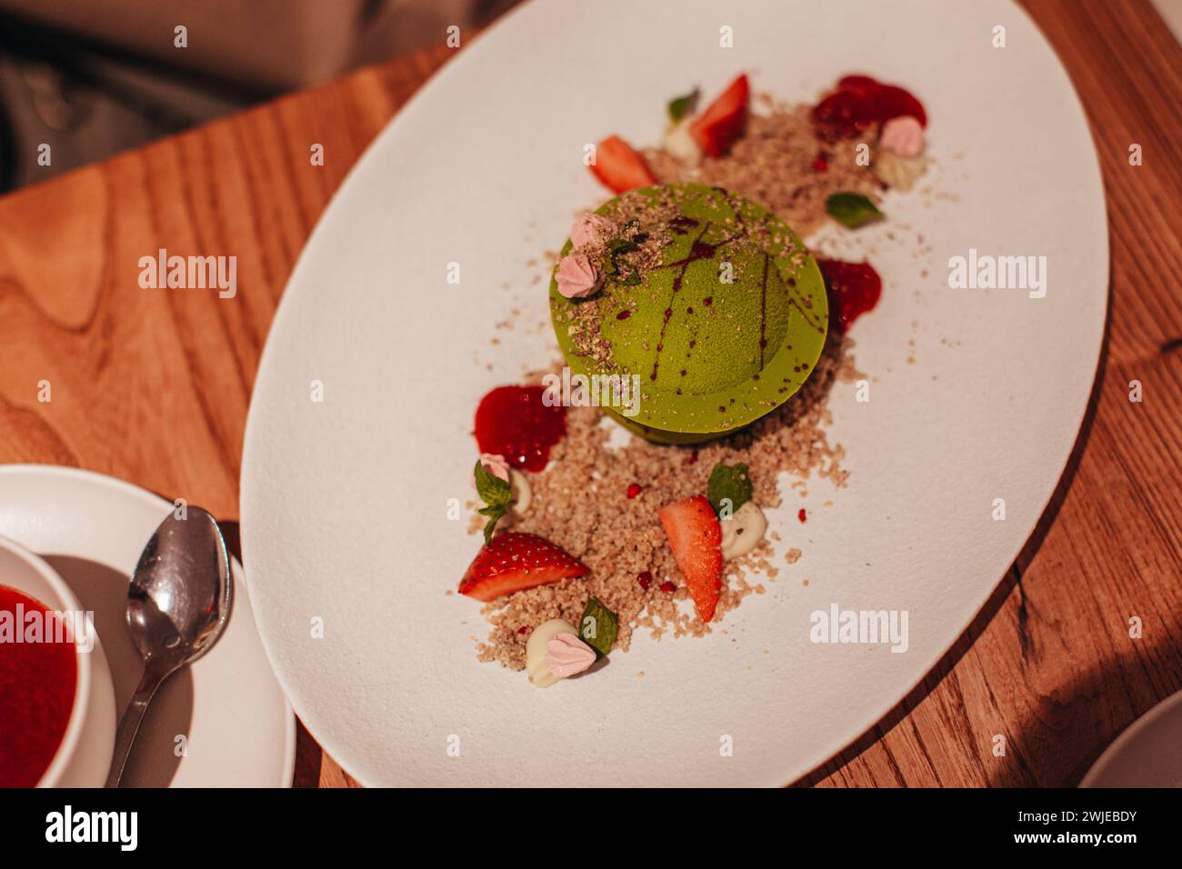 Gros plan délicieux dessert à la pistache sucrée avec des morceaux de fraises fraîches, de la confiture et de la chapelure de biscuits. Vue de dessus Banque D'Images