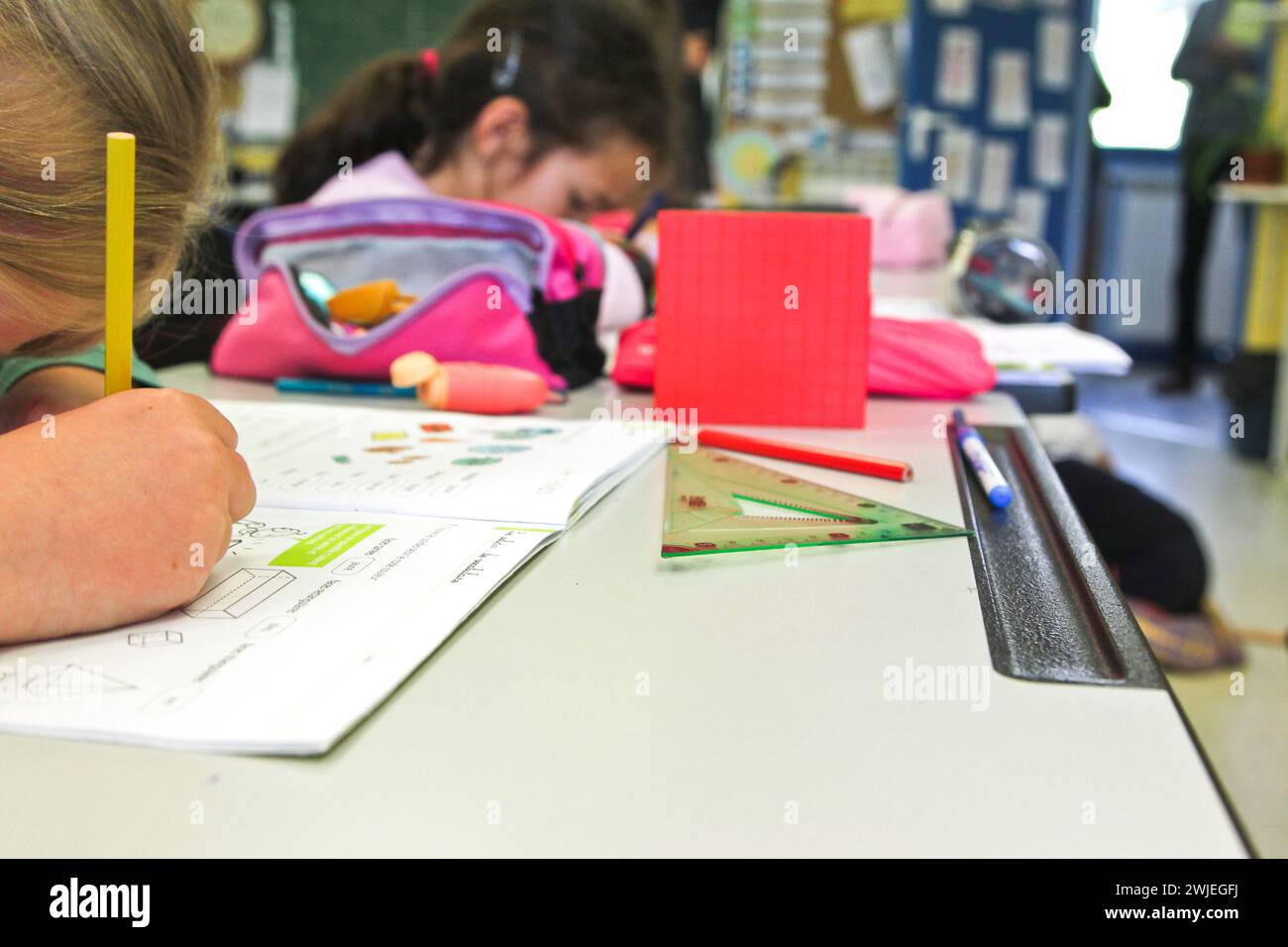 Arvieux, département des Hautes-Alpes (Alpes françaises), Queyras : classe primaire. Écolière assise à son bureau, écrivant dans son cahier d'exercices. Banque D'Images
