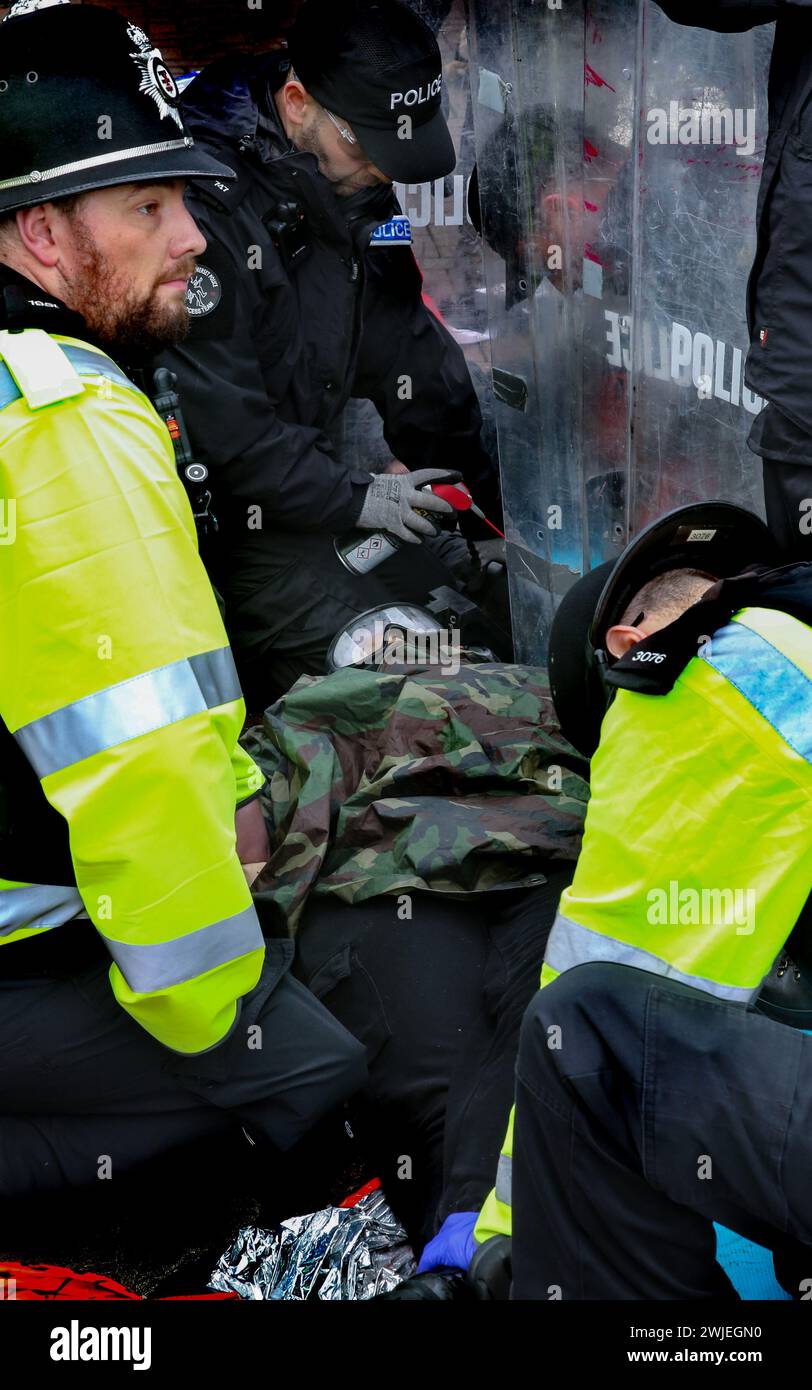 Des officiers de police spécialisés de l'équipe de découpe s'emploient à retirer un manifestant de leur verrouillage pendant la manifestation. Les partisans de Palestine action utilisent des verrous pour bloquer le seul accès des véhicules à la société de défense israélienne, l'entreprise Elbit Systems à Aztec West, Bristol. Ils soutiennent que les armes fabriquées par Elbit au Royaume-Uni sont utilisées par les Forces de défense israéliennes contre les Palestiniens à Gaza et ailleurs. Les bombardements israéliens à Gaza ont tué plus de 30 000 Palestiniens depuis octobre 2023. Palestine action est déterminée à cibler sans relâche Elbit et ses entreprises partenaires par une action directe Banque D'Images