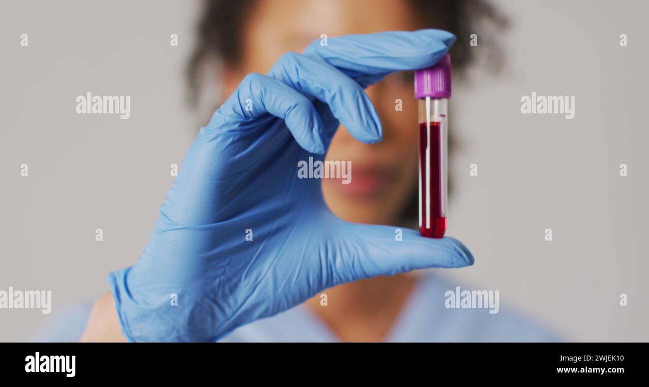 Image d'équations mathématiques sur médecin féminin biracial avec tube à essai Banque D'Images