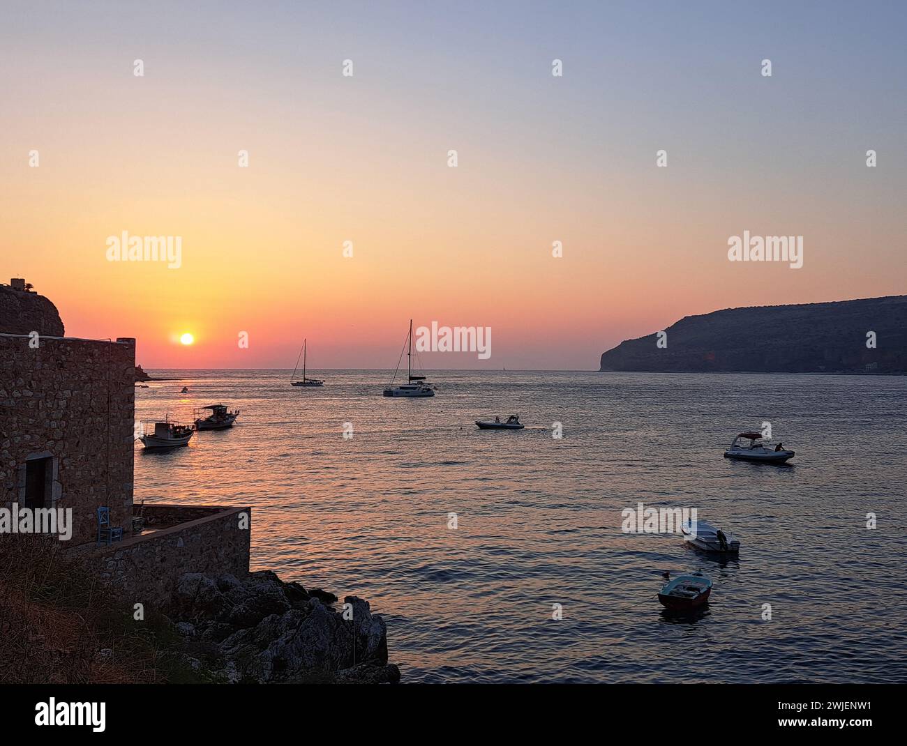Une vue panoramique de plusieurs petits bateaux dans une baie sereine près d'une structure rustique Banque D'Images