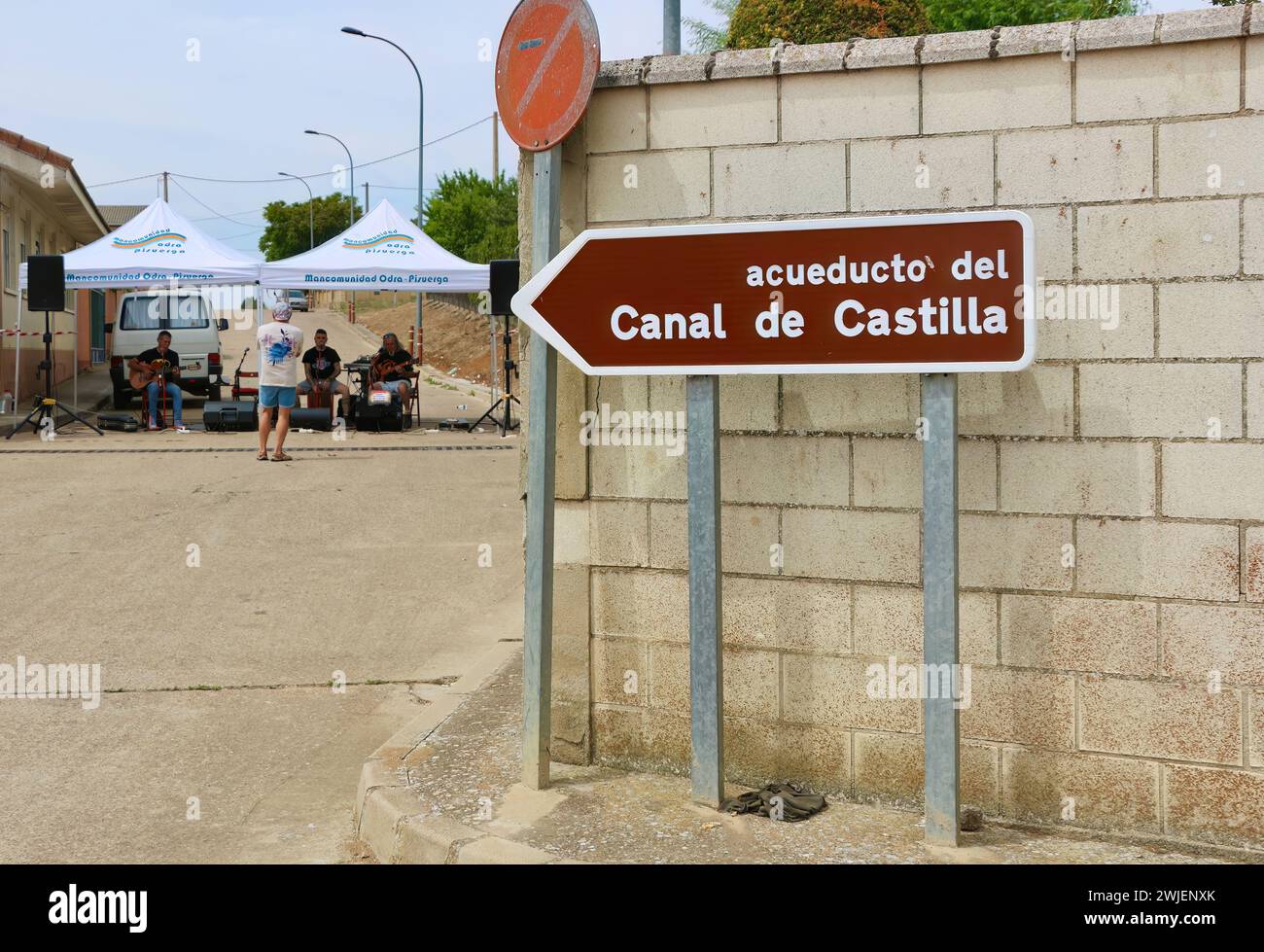 Panneau routier pour un aqueduc sur le canal de Castille avec un groupe de rock jouant sous un gazebo pendant les fêtes Lantadilla Palencia Castille et Léon Espagne Banque D'Images