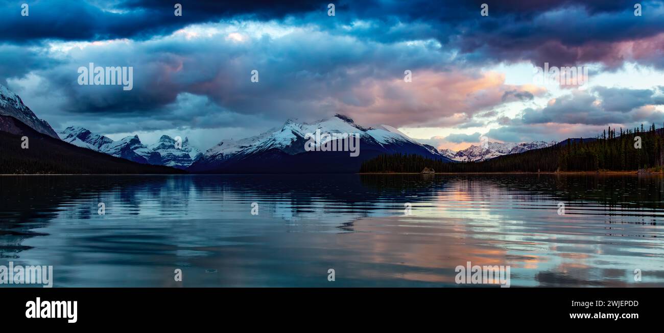 Lac glacier dans le paysage montagneux canadien. Coucher de soleil spectaculaire. Maligne Lake, Jasper, Alberta, Canada. Banque D'Images