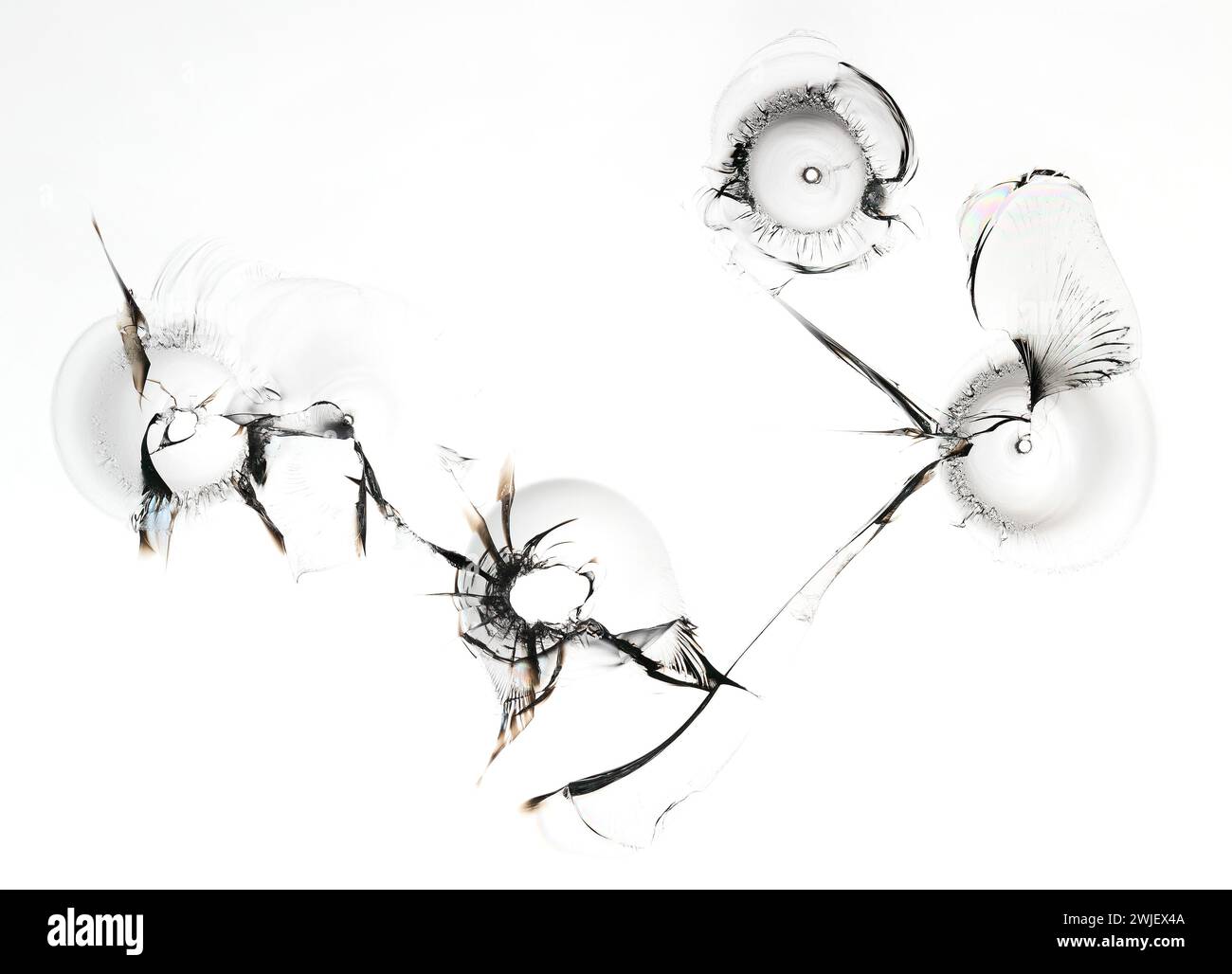 Ensemble de trous dans le verre. Texture de fenêtre cassée sur fond blanc. Macro. Banque D'Images