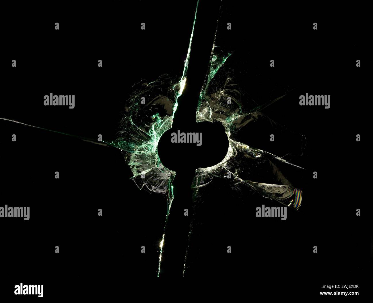 Verre cassé fissuré avec trou de balle sur fond noir. Gros plan. Banque D'Images