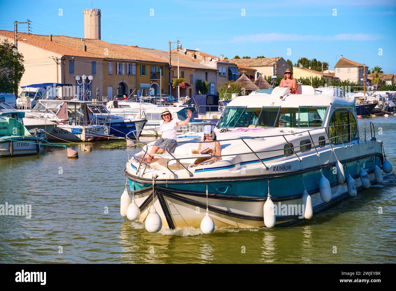 Saint-Gilles (sud de la France) : riverport sur le canal du Rhône à Sète (canal Rhône-Sète). Barge sur le canal avec trois femmes à bord Banque D'Images