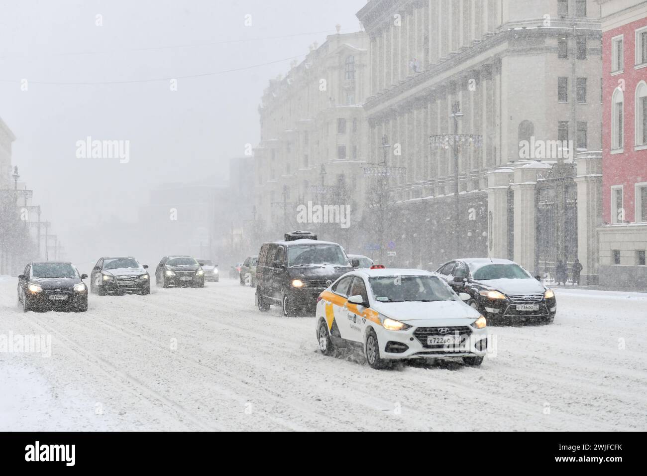 Moscou, Russie. 15 février 2024. Les véhicules circulent dans une rue au milieu des chutes de neige à Moscou, Russie, le 15 février 2024. Une forte neige a frappé Moscou jeudi. Crédit : Cao Yang/Xinhua/Alamy Live News Banque D'Images