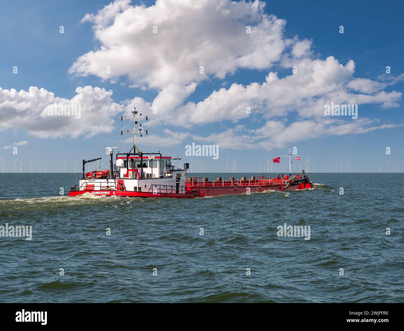 Dragueuse intérieure et téléphérique Zandexpres 5 naviguant sur le lac IJsselmeer près du parc éolien de Frise, pays-Bas Banque D'Images