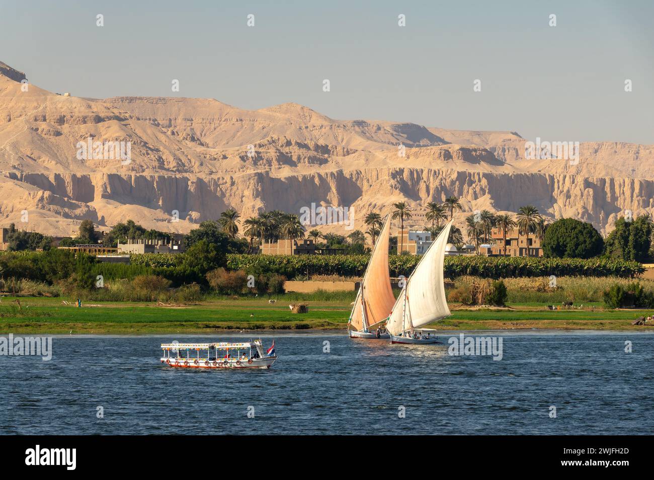 Bateaux à voile traditionnels felouques égyptiens sur le Nil, montagnes thébaines en arrière-plan à Louxor, Egypte Banque D'Images