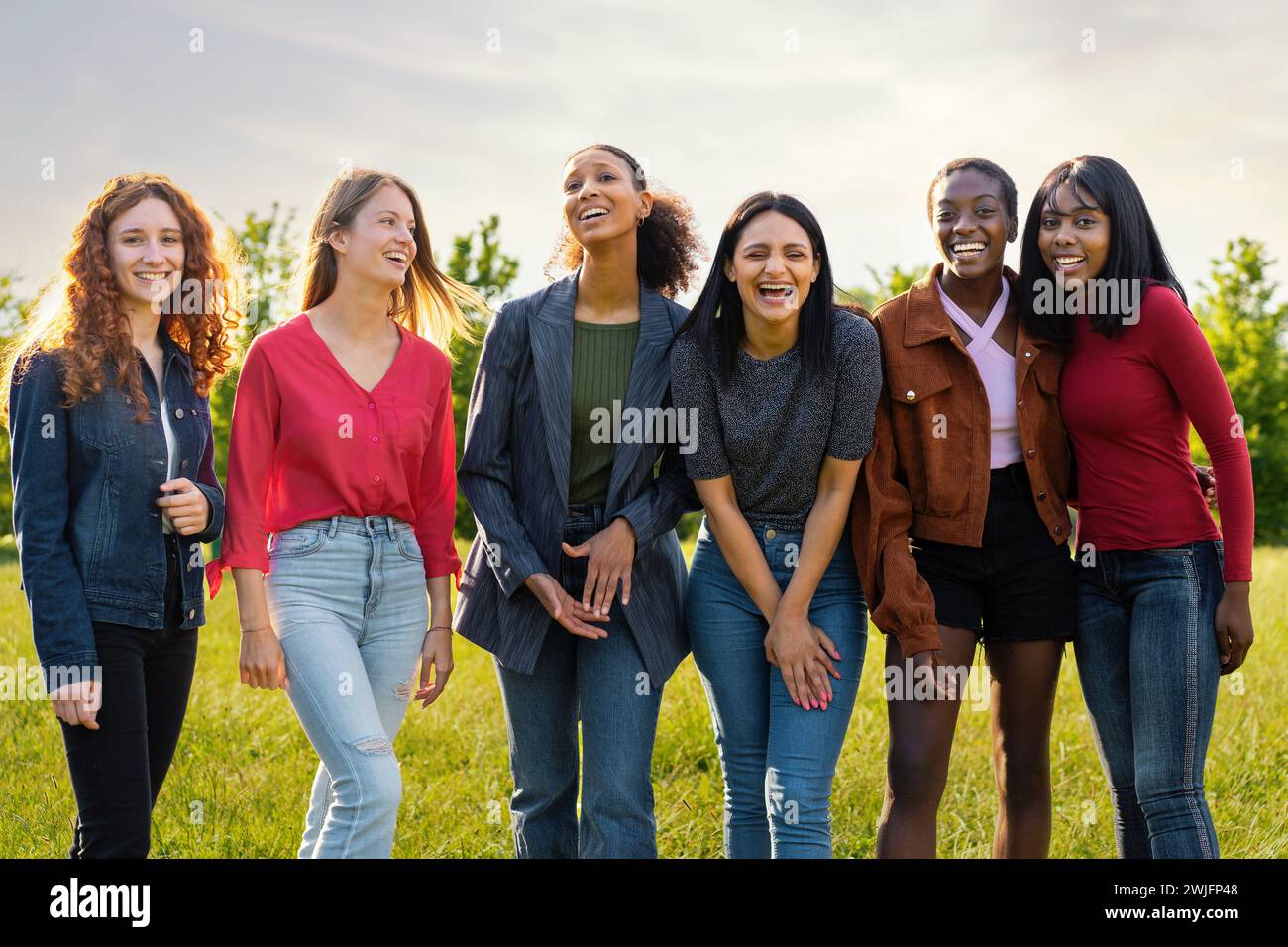 Femmes multiraciales riant ensemble à l'extérieur - embrassant la diversité et l'amitié dans un cadre naturel.- célébration de l'amitié inclusive Banque D'Images Femmes multiraciales riant ensemble à l'extérieur - embrassant la diversité et l'amitié dans un cadre naturel.- célébration de l'amitié inclusive Banque D'Images