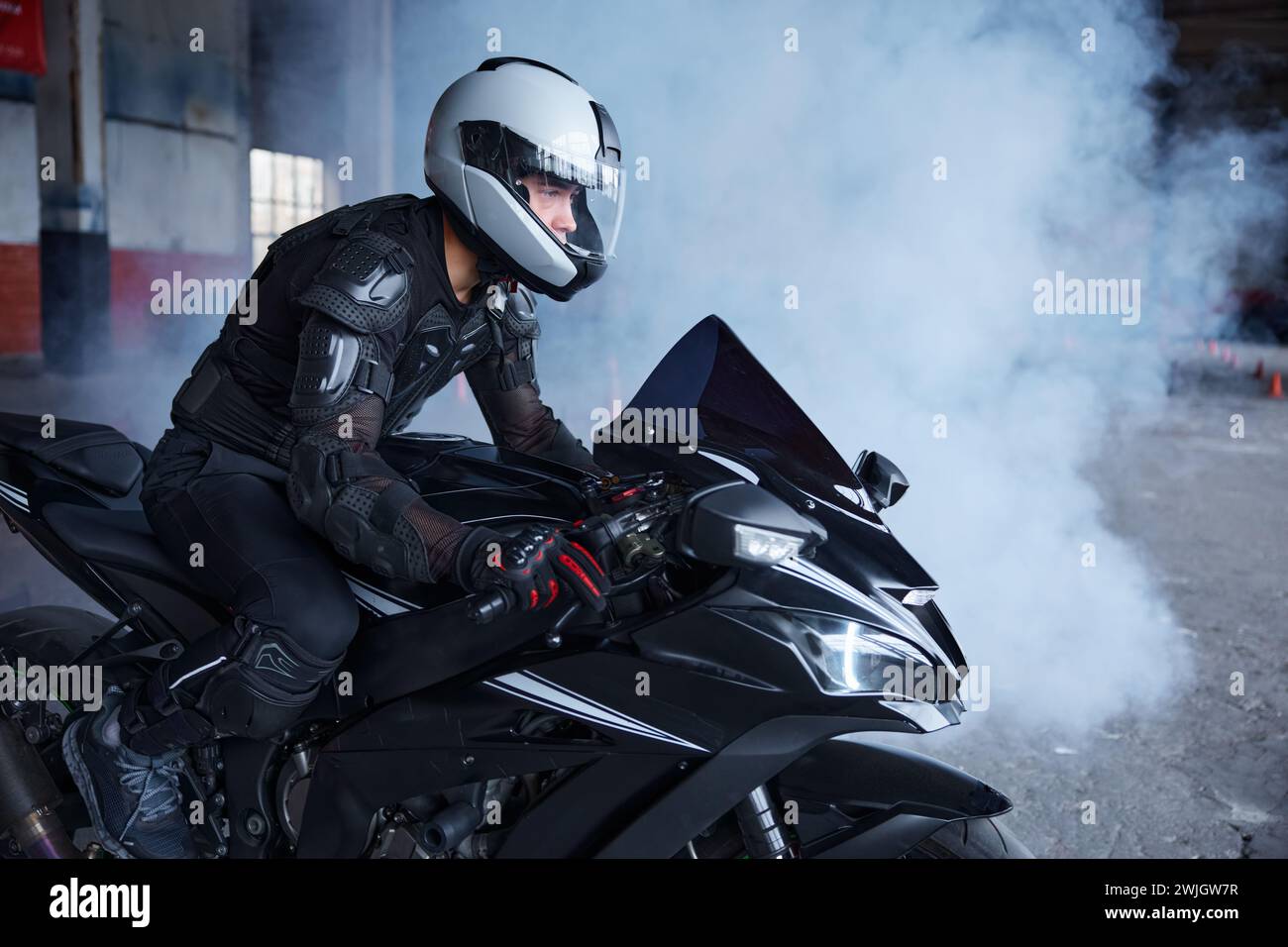 Biker portant un casque de protection et un uniforme pour la conduite de vitesse à la classe d'entraînement Banque D'Images