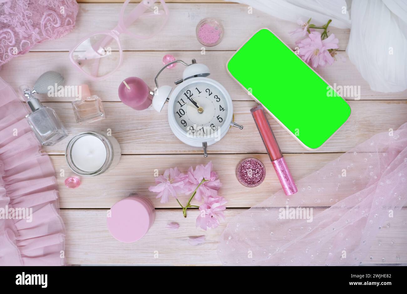 tasse à café, smartphone avec écran vert vierge, cosmétiques, parfum en vaporisateur, beignet, fleurs de sakura, concept de bon matin, heure du café en boudoi Banque D'Images