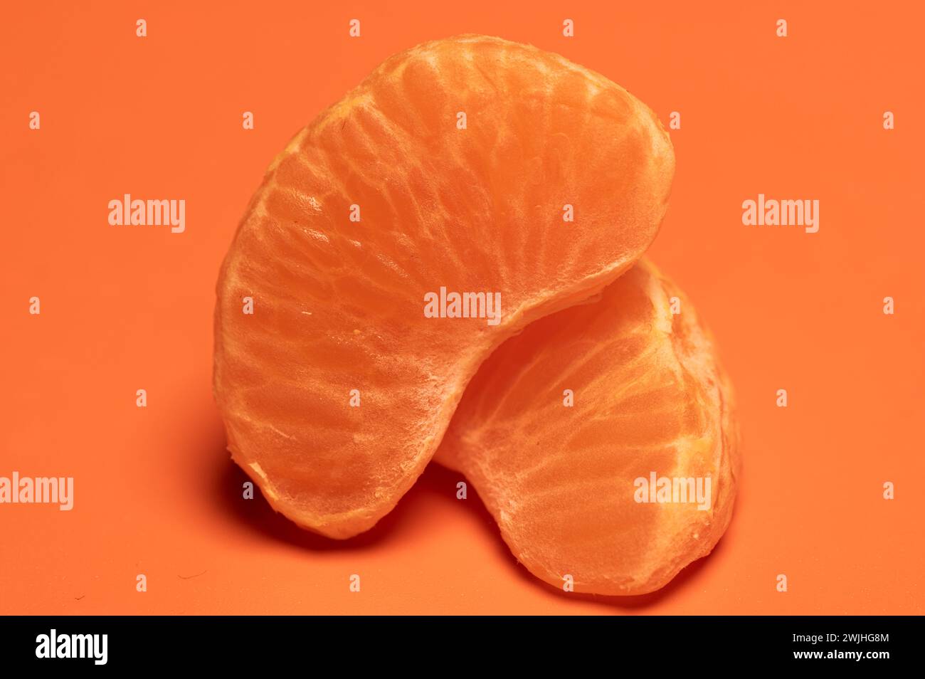 , Food, Deutschland, 15.02.2024, Saftige Mandarinenstücke auf orangefarbenem Hintergrund in Nahaufnahme. Banque D'Images