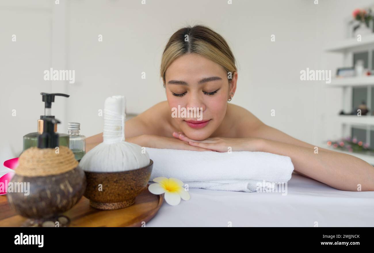 Femme recevant un massage spa aux pierres chaudes. Allongé sur une table de massage, relaxant avec les yeux fermés. Spa soins thermaux aromathérapie pour le corps de beauté. S Banque D'Images