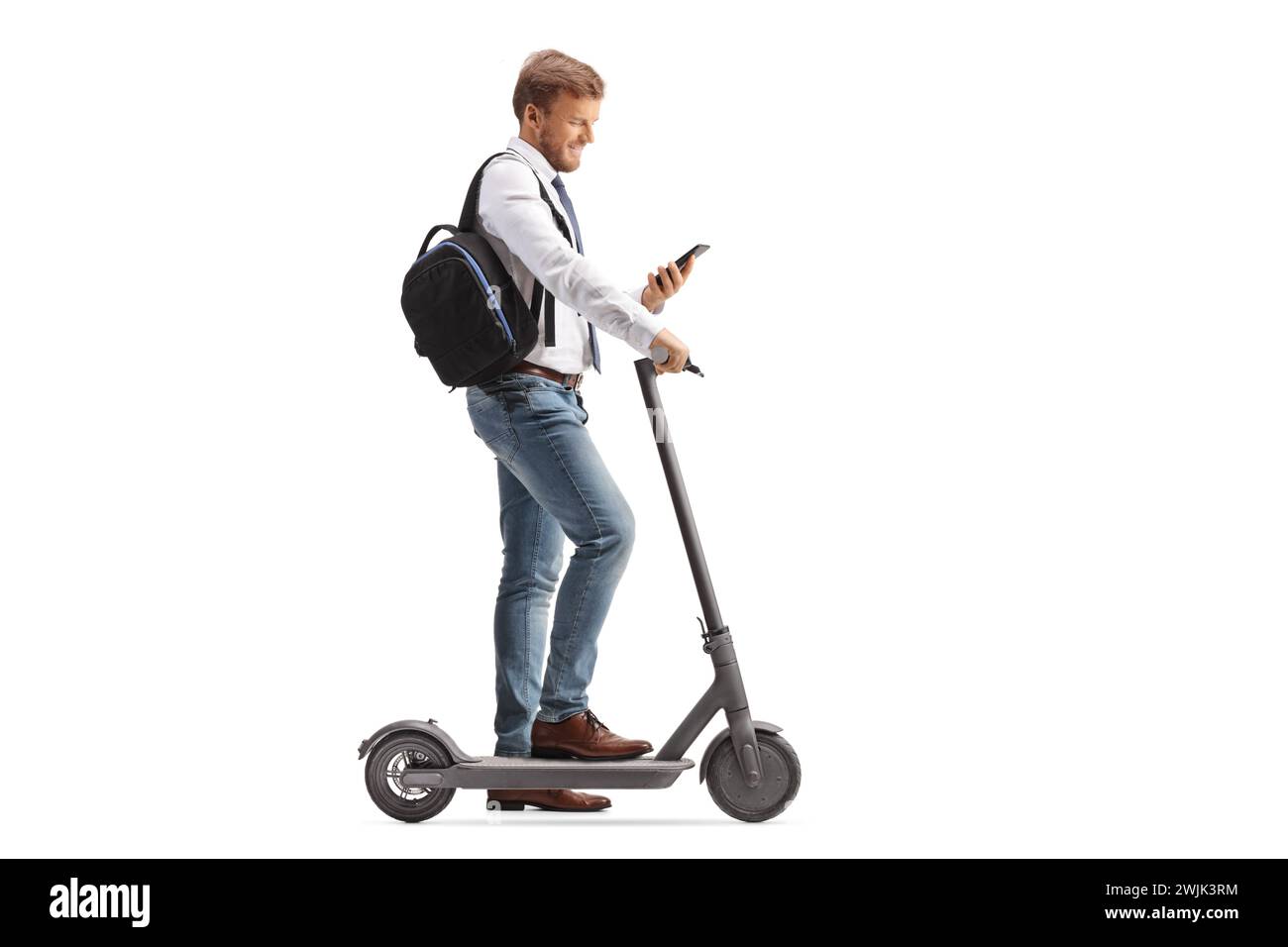 Plan de profil pleine longueur d'un homme avec scooter électrique vérifiant son smartphone isolé sur fond blanc Banque D'Images