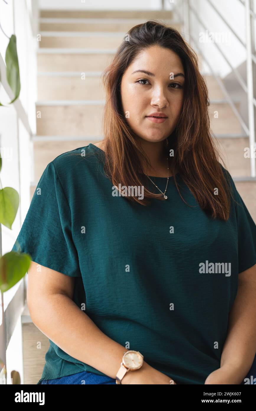 Jeune femme biraciale de taille plus se tient confiant à la maison Banque D'Images