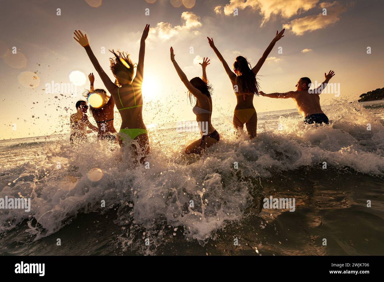 Grand groupe de jeunes amis heureux de touristes s'amusent, court et saute à la plage de la mer au coucher du soleil. Concept week-end tropical Banque D'Images