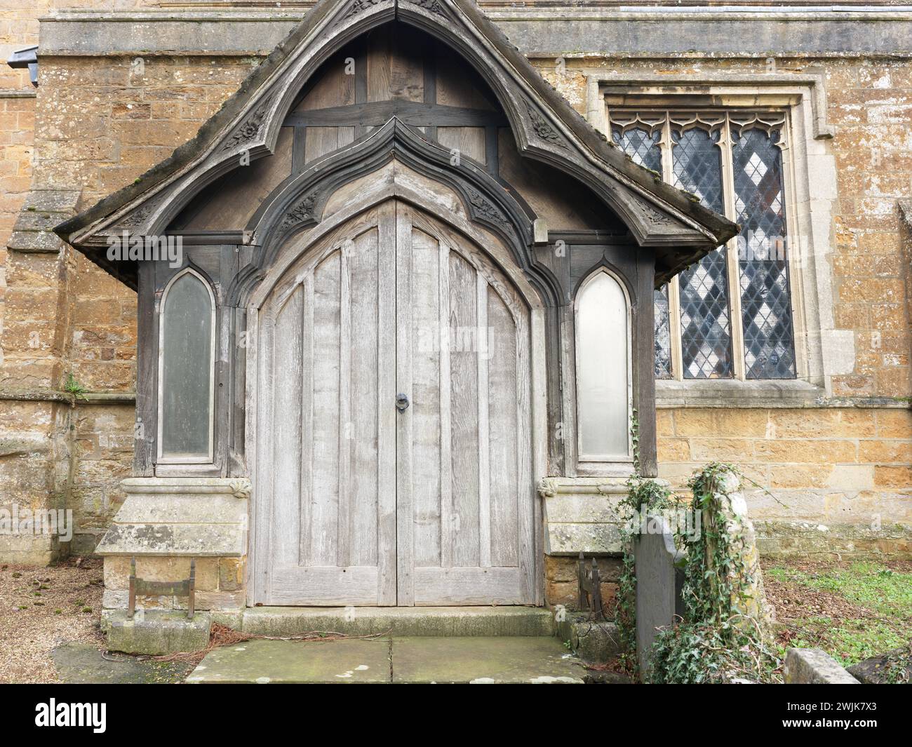 Porte latérale en bois à l'église paroissiale de St Peter et St Paul dans la ville marchande d'Uppingham, Rutland, Angleterre. Banque D'Images
