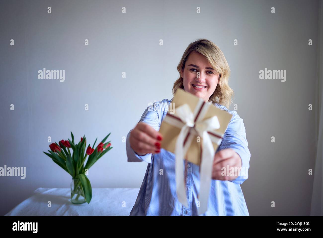 femme de taille moyenne tient un certificat cadeau artisanal dans ses mains Banque D'Images