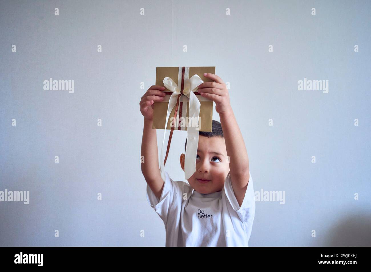 un petit garçon tient un certificat cadeau artisanal dans ses mains Banque D'Images