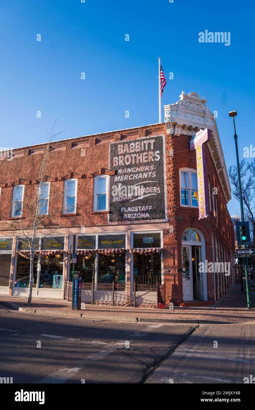 Un vieux bâtiment, Babbit Brothers, à Flagstaff, à l'angle de San Francisco Street et Aspen Avenue. Drapeau américain, lumière du soleil du soir, ciel bleu. SPR Banque D'Images