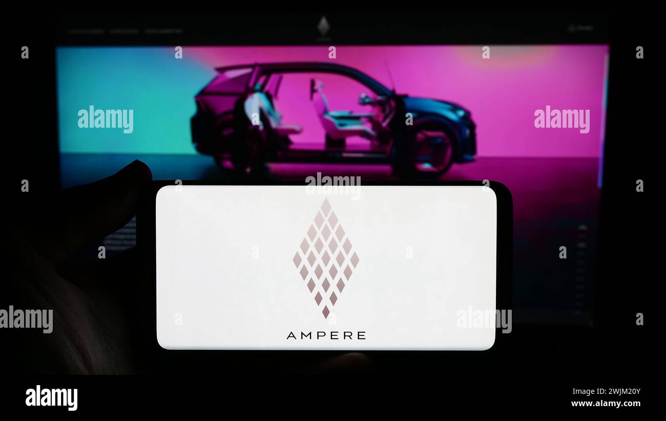 Personne détenant un smartphone avec le logo de la société française de voitures électriques Ampere SAS (Renault) en face du site. Concentrez-vous sur l'affichage du téléphone. Banque D'Images