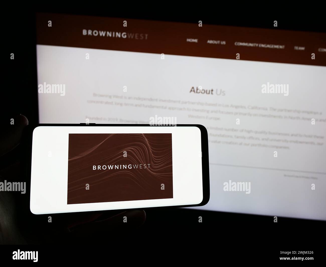 Personne tenant un smartphone avec le logo de la société d'investissement américaine Browning West LP devant le site Web. Concentrez-vous sur l'affichage du téléphone. Banque D'Images