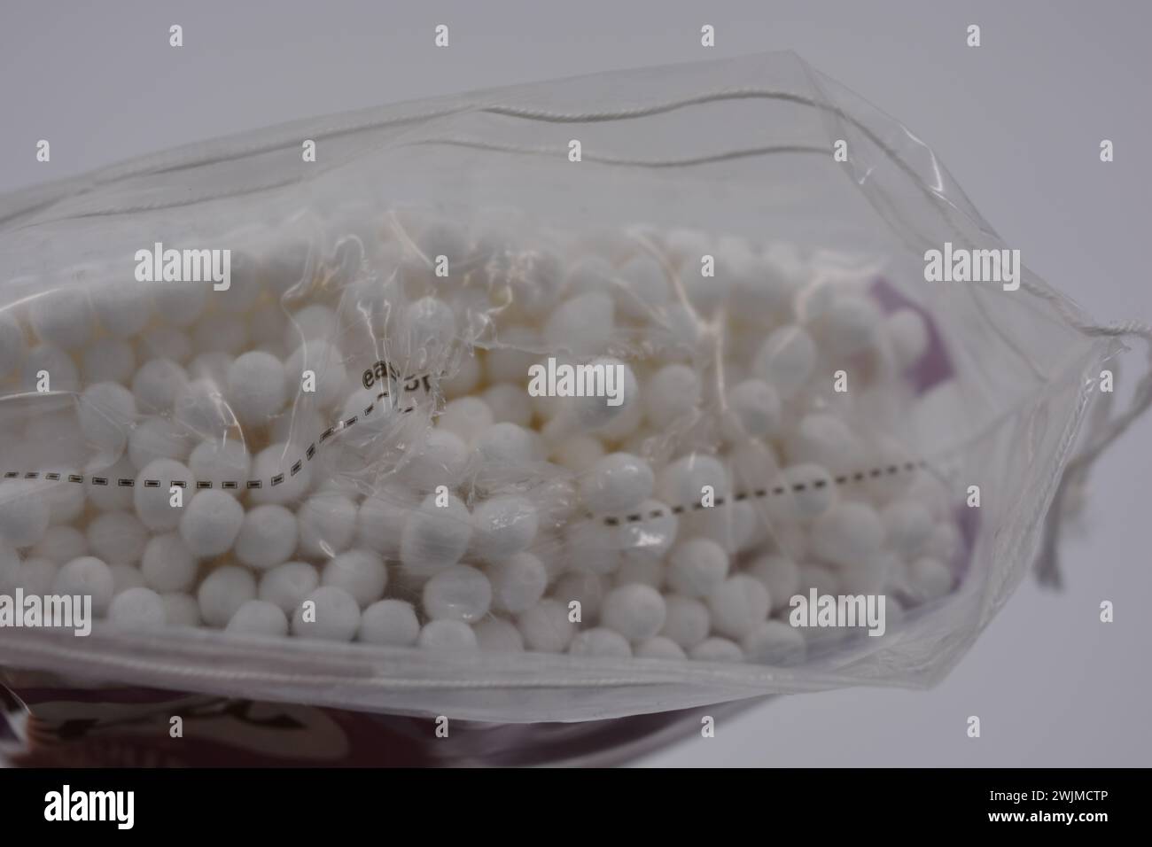 Les produits d'hygiène, les cosmétiques pour la maison, les produits de soin, les cotons-tiges blancs stériles pour le nettoyage des oreilles sont emballés dans un emballage en plastique et placés sur un blanc. Banque D'Images