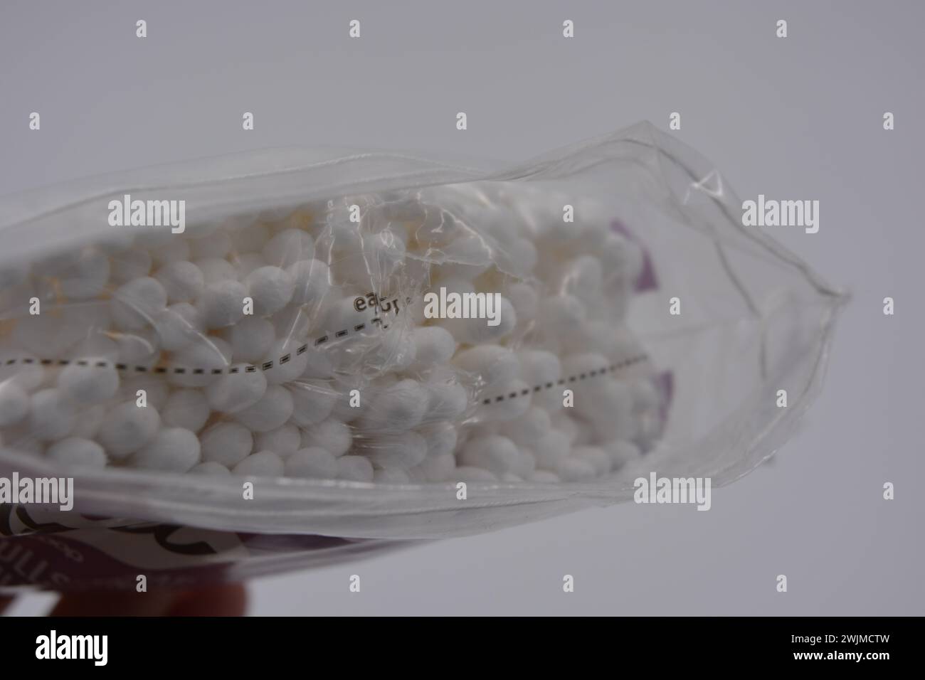 Les produits d'hygiène, les cosmétiques pour la maison, les produits de soin, les cotons-tiges blancs stériles pour le nettoyage des oreilles sont emballés dans un emballage en plastique et placés sur un blanc. Banque D'Images