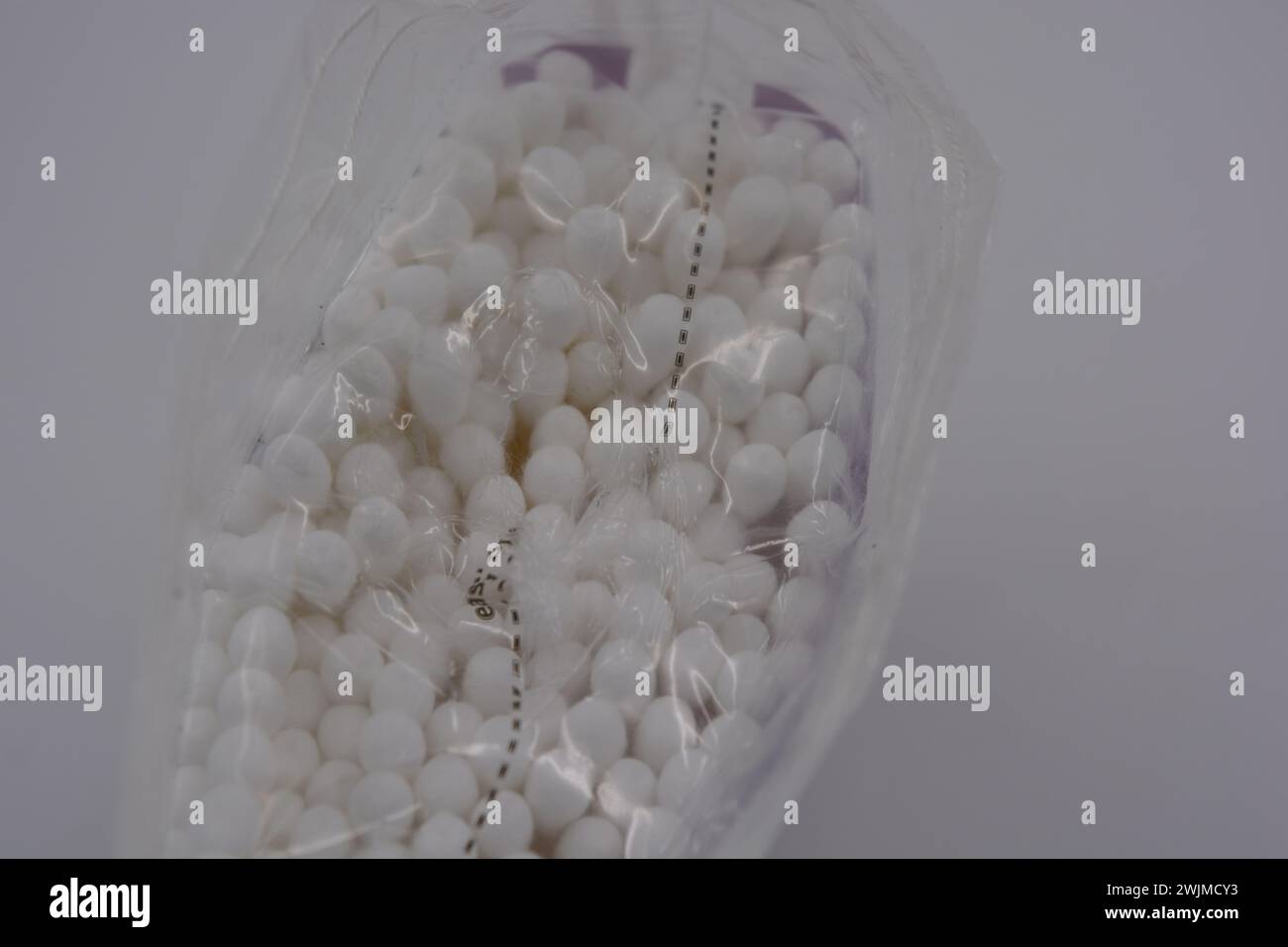 Les produits d'hygiène, les cosmétiques pour la maison, les produits de soin, les cotons-tiges blancs stériles pour le nettoyage des oreilles sont emballés dans un emballage en plastique et placés sur un blanc. Banque D'Images