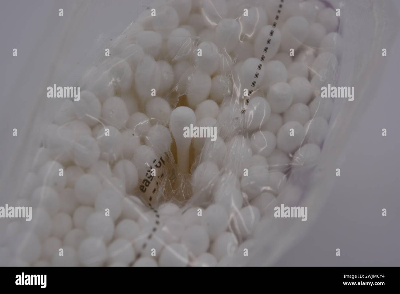 Les produits d'hygiène, les cosmétiques pour la maison, les produits de soin, les cotons-tiges blancs stériles pour le nettoyage des oreilles sont emballés dans un emballage en plastique et placés sur un blanc. Banque D'Images