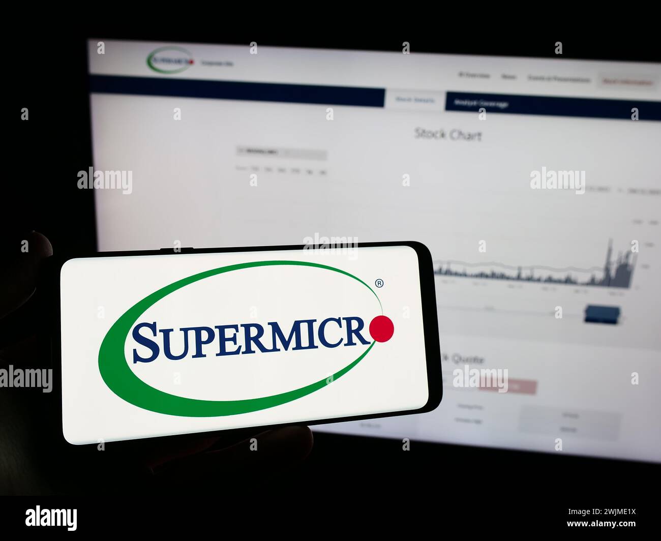 Personne tenant le téléphone portable avec le logo de la société américaine Super Micro Computer Inc (Supermicro) devant la page web. Concentrez-vous sur l'affichage du téléphone. Banque D'Images