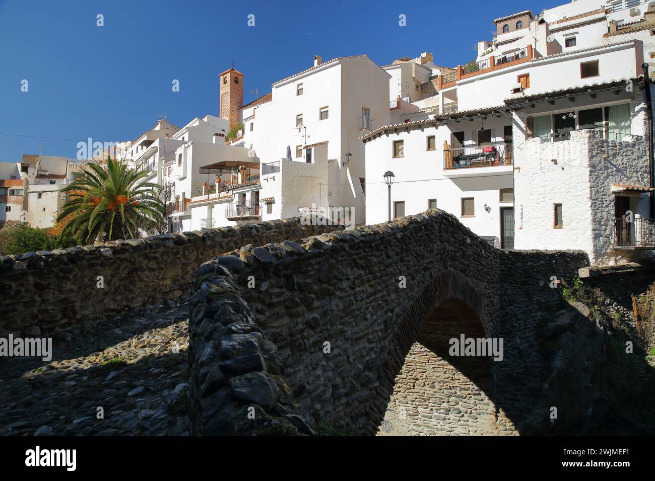 Le village de Salares, Axarquia, province de Malaga, Andalousie, Espagne, avec des maisons blanchies à la chaux, le pont romain et son minaret Banque D'Images