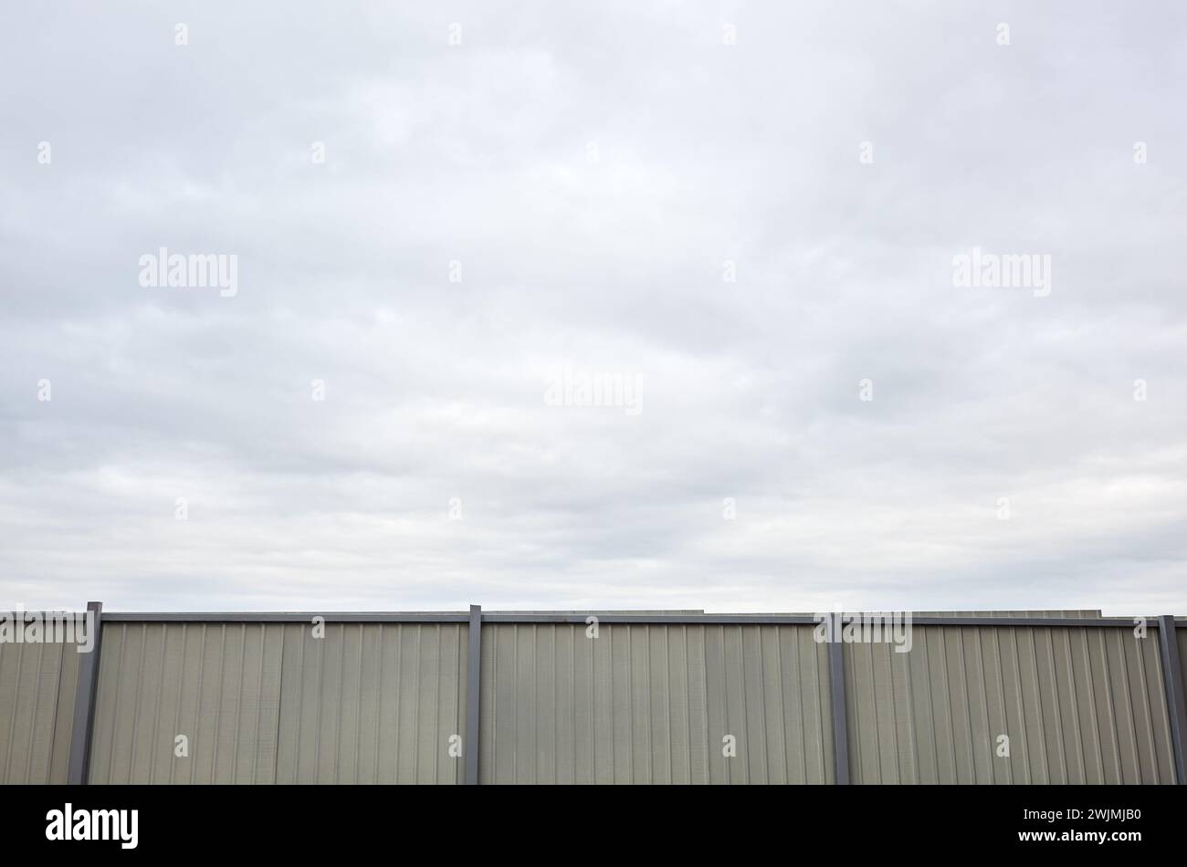 Clôture en acier ondulé contre le ciel bleu. Surface de texture métallique ondulée ou galvaniser l'acier Banque D'Images