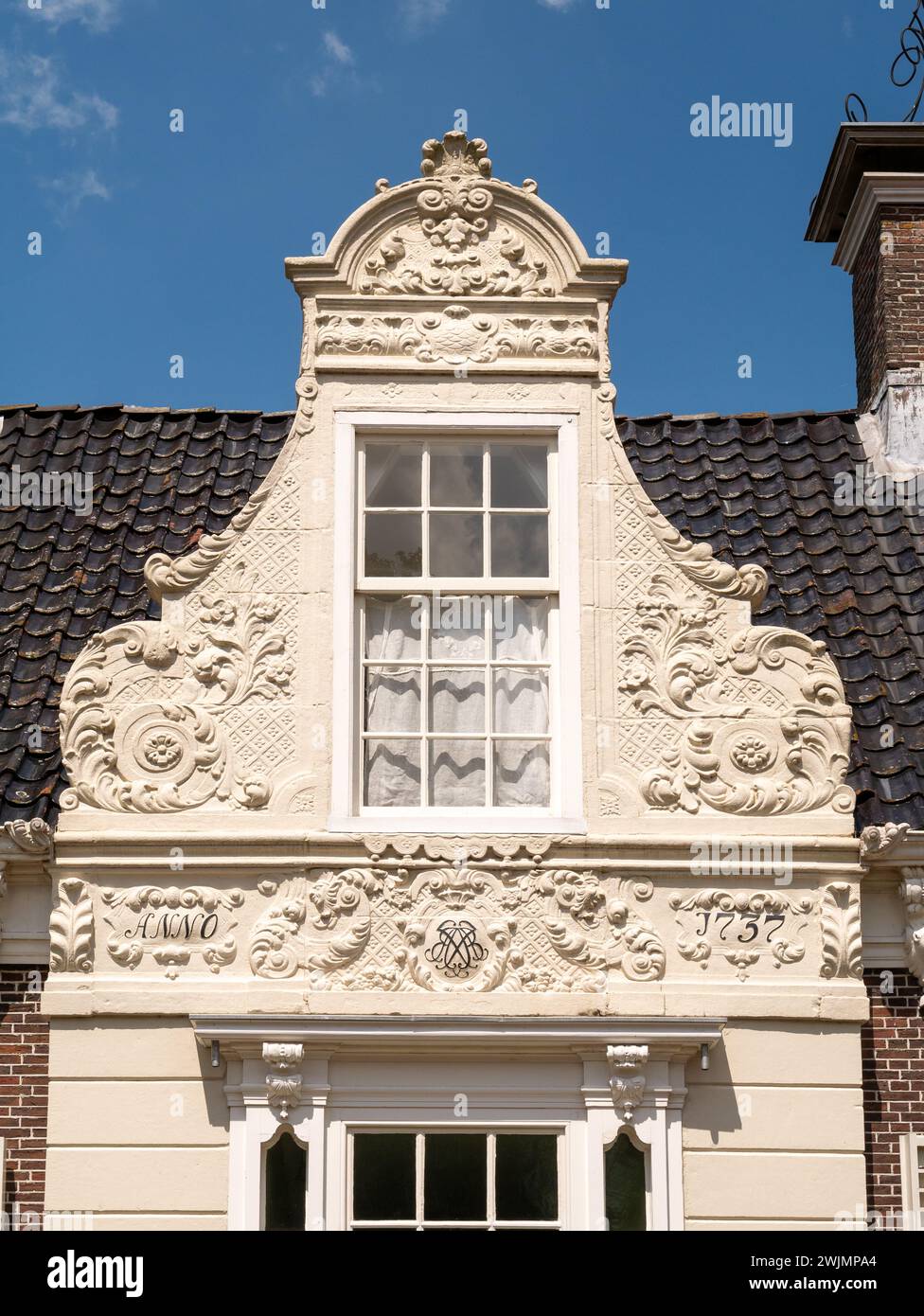 Pignon de cloche en grès décoré dans le style baroque d'une ancienne maison de skippers de foin dans le centre de Heeg, Frise, pays-Bas Banque D'Images