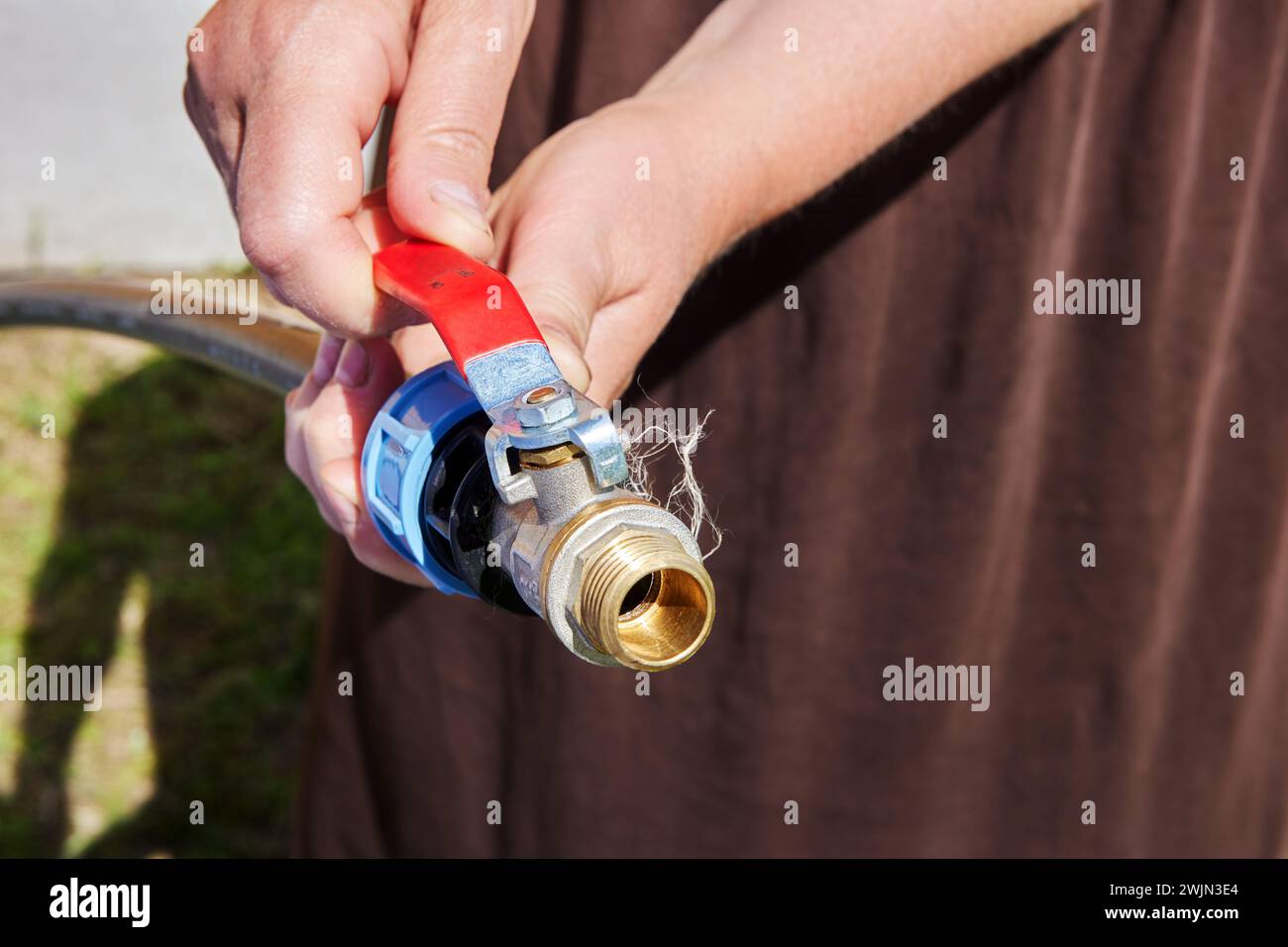 Utilisation d'un adaptateur fileté PP pour connecter le robinet à boisseau sphérique en laiton au tuyau en polyéthylène pour arroser le potager. Banque D'Images