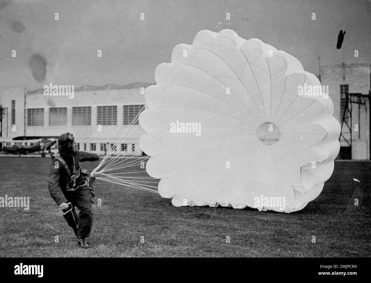 Happy Landing : un moment palpitant pour tout cadet R.A.F. sa première descente en parachute et un atterrissage heureux. C'est une scène à l'école de formation R.A.F. à Hullavington dans le Wiltshire. Avec le développement de la R.A.F. de nouvelles écoles ont été ouvertes pour la formation des pilotes. 12 octobre 1937. (Photo de Topical Press). Banque D'Images