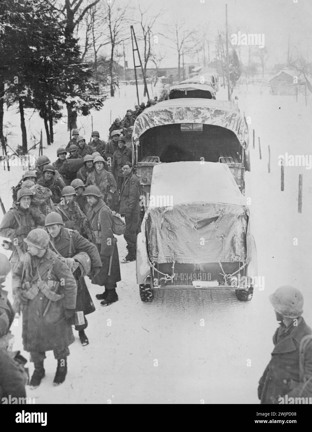 Les troupes aéroportées américaines en Belgique se préparent à se déplacer -- les hommes de la 82ème Division aéroportée font la queue pour barder les camions le long d'une route enneigée quelque part en Belgique. Ces troupes, sous le commandement du major-général James Savin, âgé de 37 ans, ont participé aux combats en Sicile et sur le continent italien et ont fait partie des forces américaines débarquées en Normandie 'jour J' (6 juin 1944). Au cours de la course à Arnhem, en Hollande, ils se distinguent en capturant et en tenant des ponts essentiels à l'avancée des forces alliées. 26 février 1945. (Photo par U. S. signal corps). Banque D'Images