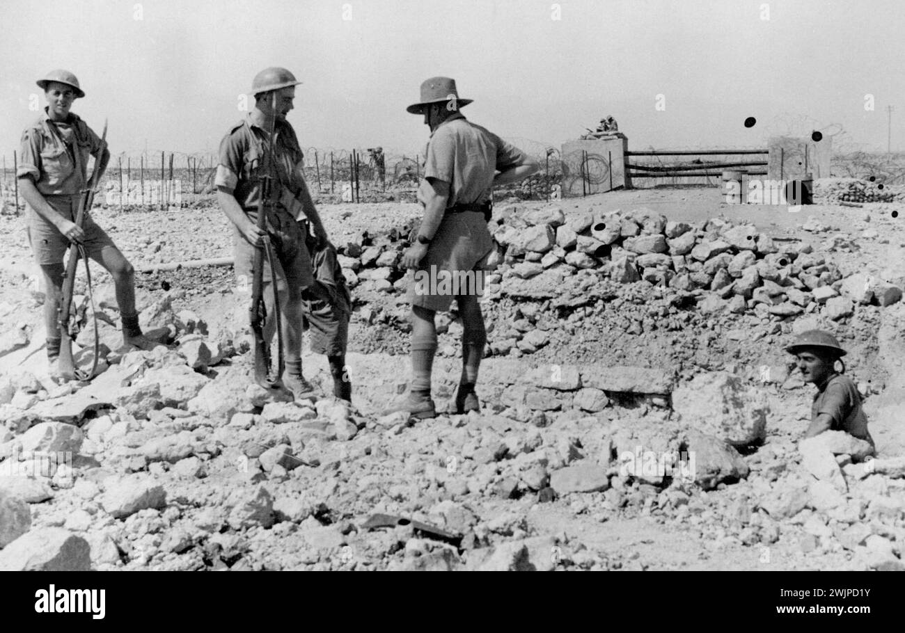 Le colonel F. Burrows avec un chapeau souple et certains de ses hommes patrouillant le fil des défenses extérieures de Tobrouk. Les défenses sont surveillées nuit et jour pour vérifier toute tentative ennemie de pénétration. 1er juin 1941. Banque D'Images