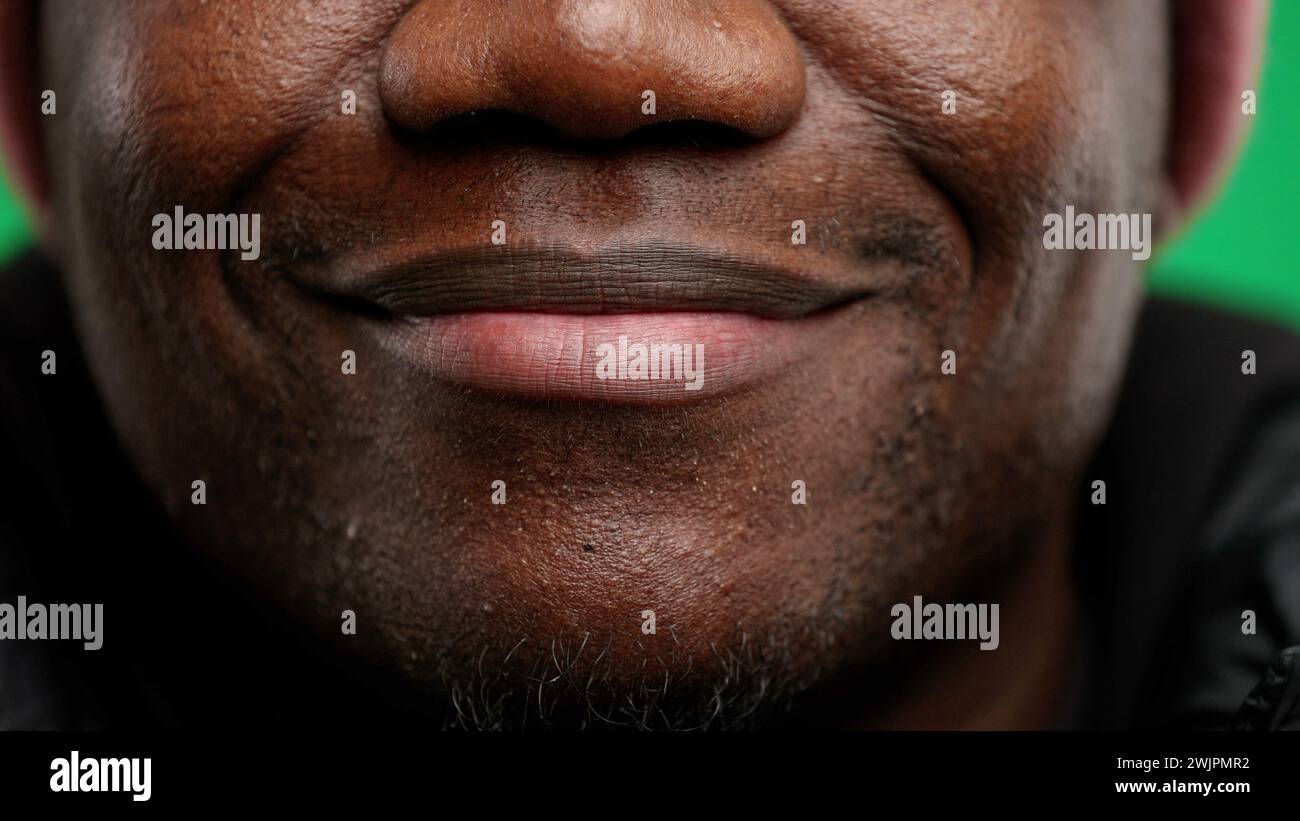 Bouche d'homme, gros plan, sur fond vert. Banque D'Images