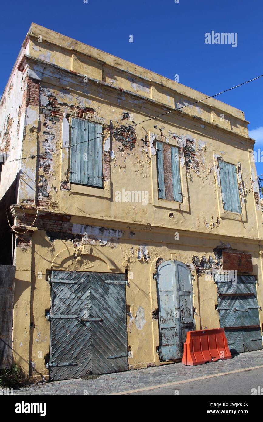 Bâtiment abandonné en pierre jaune avec volets boisés bleus à Charlotte Amalie, St Thomas, Îles Vierges américaines Banque D'Images