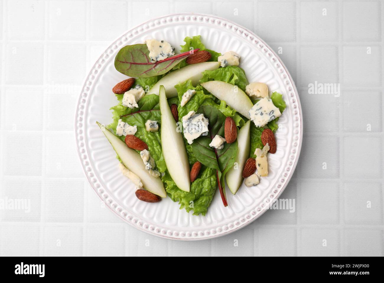 Délicieuse salade de poires sur table carrelée blanche, vue de dessus Banque D'Images